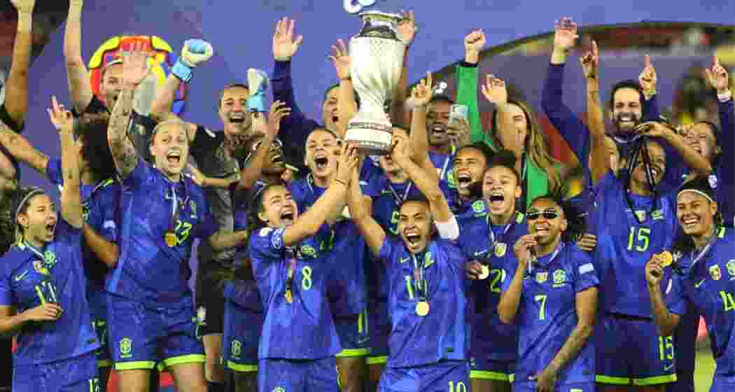 Brazilian players lift the Copa America Femenina trophy.