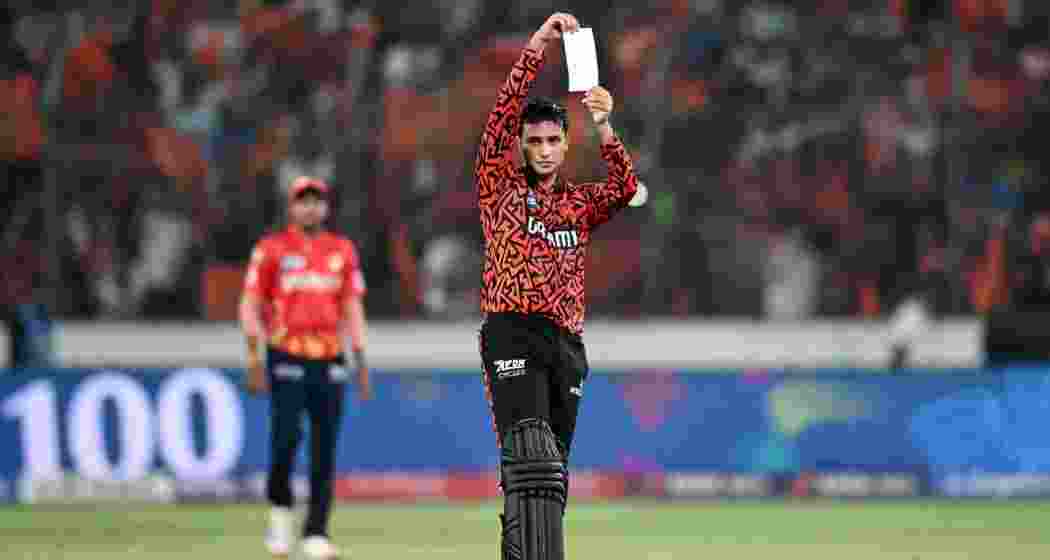 Abhishek Sharma celebrates after scoring a blistering century, revealing a note dedicated to the Orange Army, as he powers Sunrisers Hyderabad to a thrilling eight-wicket win over Punjab Kings.

