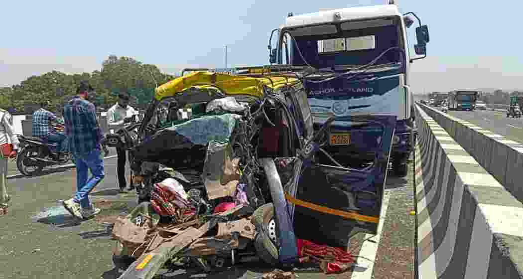 Locals gather around the mangled remains of an Eeco van after a fatal collision with a cement mixer on Panjar bridge in Thane, killing 11 passengers, on Monday.