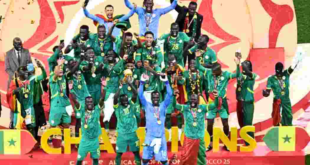 Senegal players celebrate with the trophy after winning the Africa Cup of Nations (CAN) final football match against Morocco at the Prince Moulay Abdellah Stadium in Rabat on Sunday.