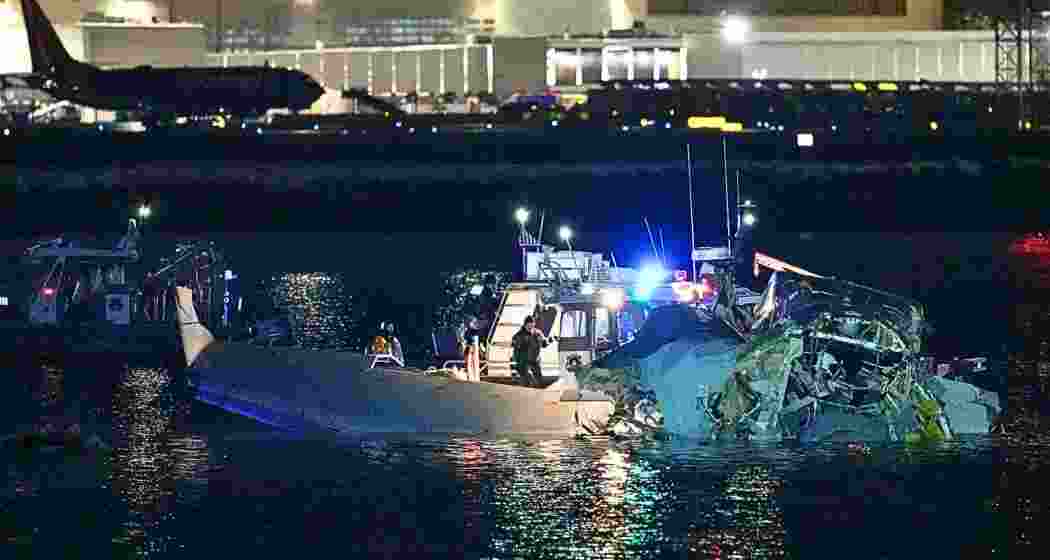 Rescue teams retrieve debris from the American Airlines plane and Black Hawk helicopter crash site in the icy waters of the Potomac River near Reagan Airport.