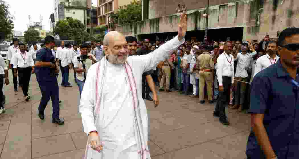 Union Home Minister Amit Shah waves during his visit to the Nagardevi Bhadrakali Mata Temple, in Ahmedabad, Sunday.