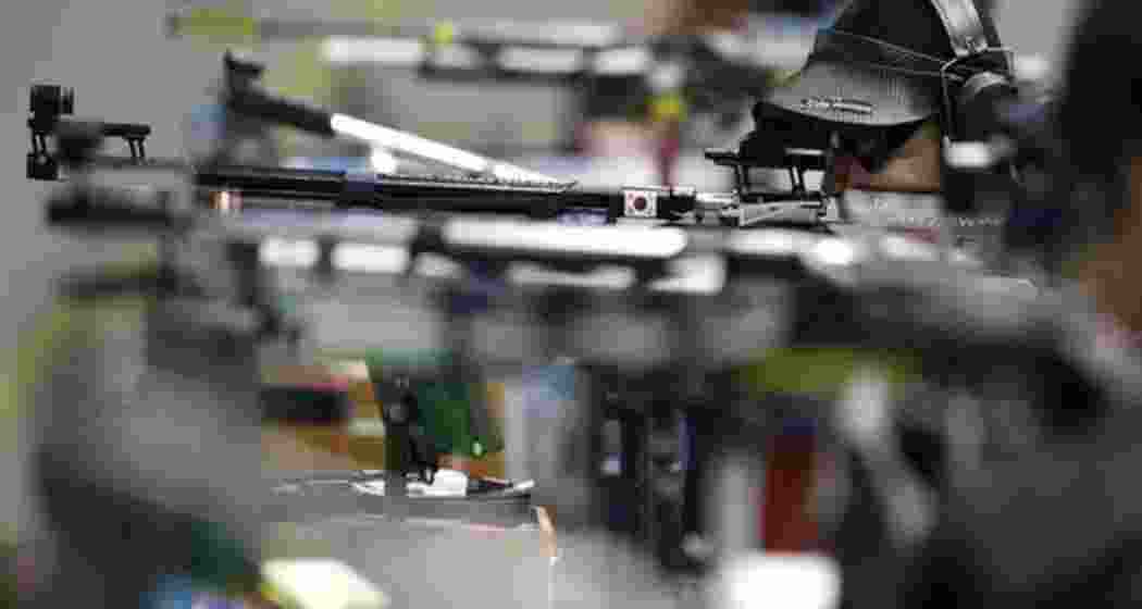 Players lined up, rifles raised, taking aim at targets during the Asian Shooting Championship