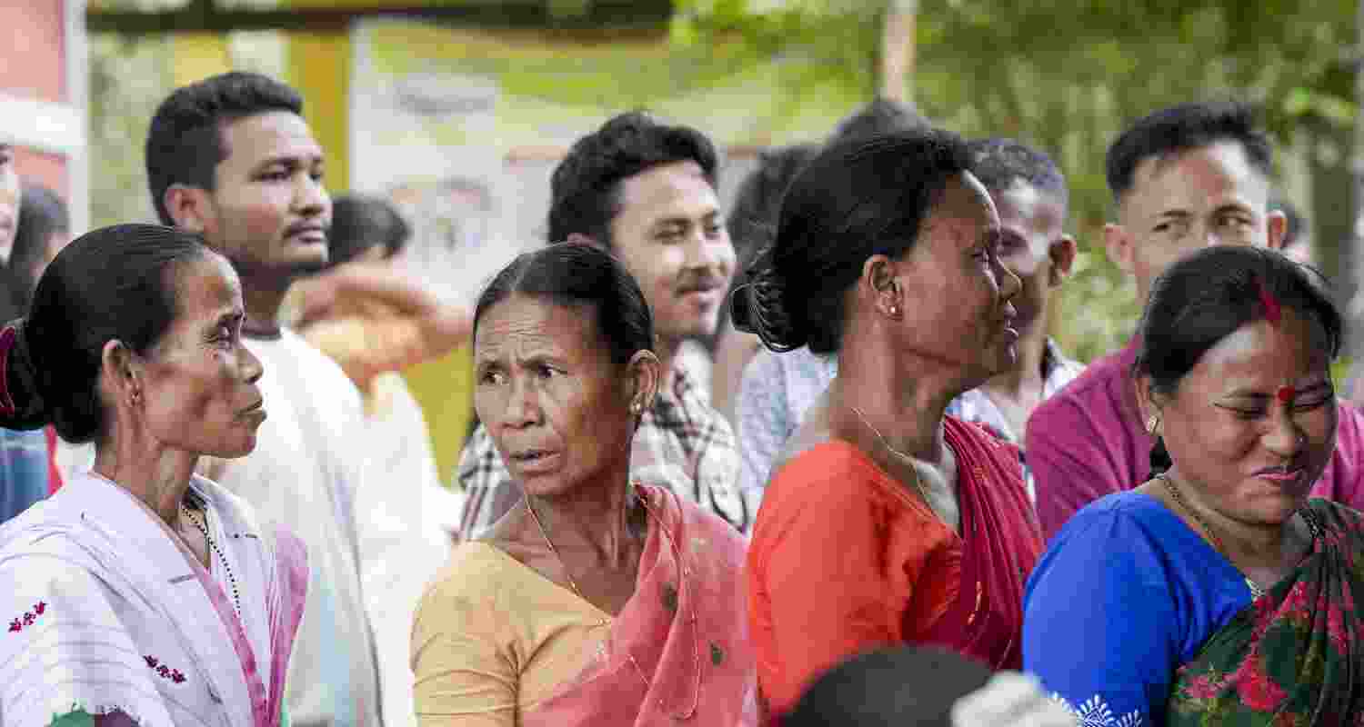 People wait in a queue to cast their votes during the Assam Assembly elections, at a polling station at Sonapur, in Kamrup district, Thursday, April 9, 2026.
