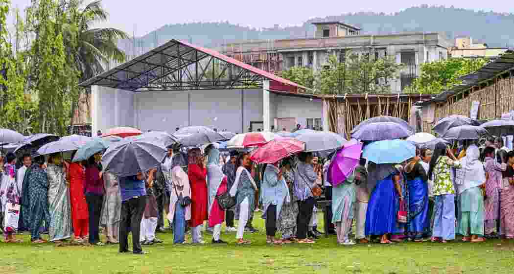 People queue up to cast their votes during the Assam Assembly elections, at a polling station, in Guwahati, Assam, on Thursday.