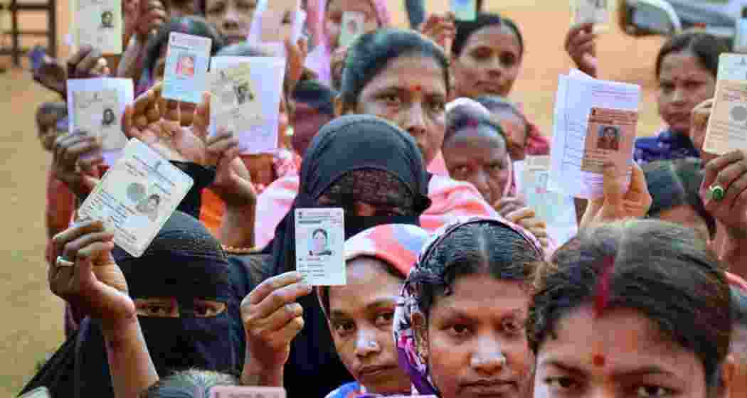 Voters stand in a queue at a polling station in Assam during the 2024 Lok Sabha elections, waiting to cast their ballots amid heavy turnout across the state.