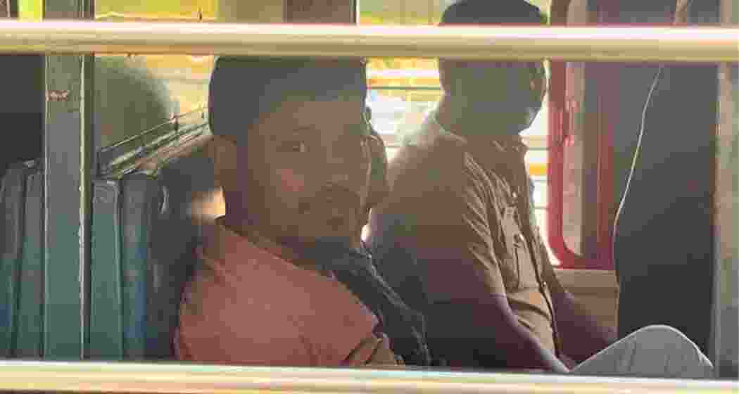 An illegal Bangladeshi migrant looks out of a train window while being deported to Bangladesh under police escort.