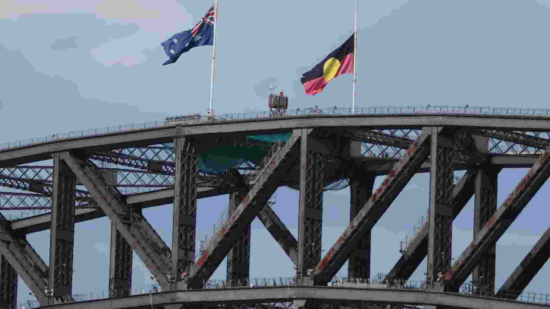 Australian and Aboriginal flags fly at half staff on the Sydney Harbour Bridge during a National Day of Reflection to honour the victims of the last Sunday’s terrorist attack at Bondi Beach, Sunday.