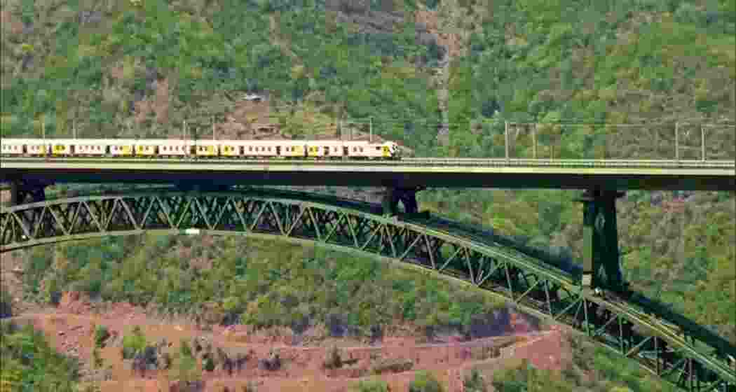 A train crosses the iconic Chenab Bridge during a trial run ahead of its formal inauguration by Prime Minister Narendra Modi.
