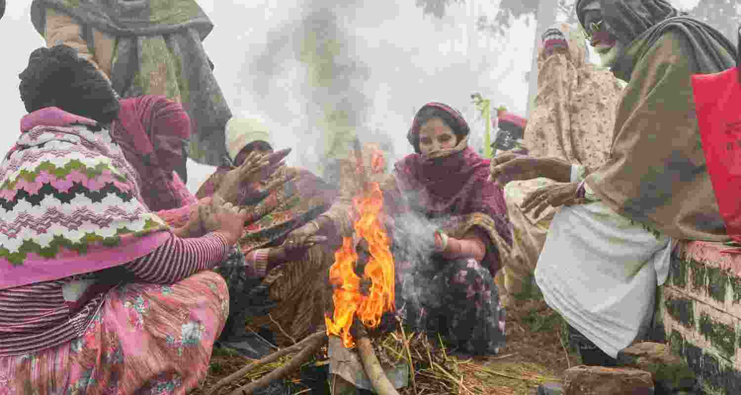 People warm themselves around a bonfire on a foggy winter morning, on the outskirts of Amritsar. People warm themselves around a bonfire on a foggy winter morning, on the outskirts of Amritsar.