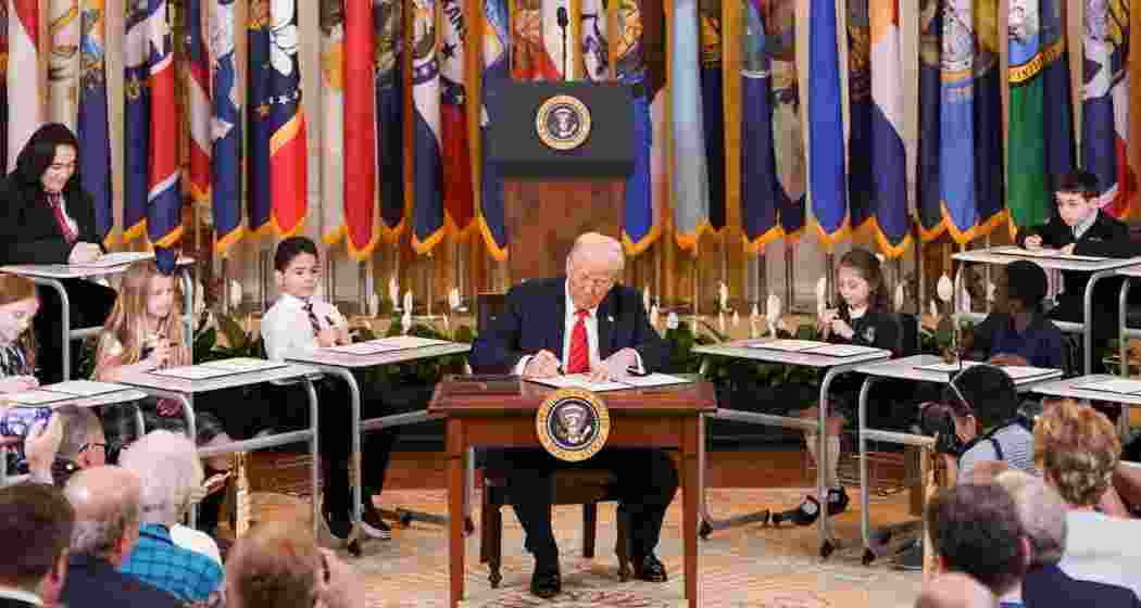 Children hold up Executive Orders as Donald Trump signs the decree to abolish the US Education Department at a formal ceremony on Thursday.