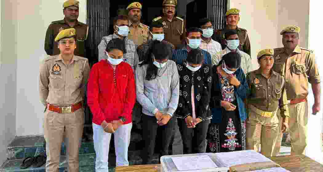 Security personnel with the solver gang involved in the UP Board exams after their arrest. A total of 16 individuals were apprehended for unlawfully solving question papers.