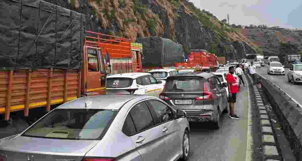 Commuters stand idle as traffic remains halted on the Mumbai-Pune Expressway near Khopoli during the 33-hour disruption following a gas tanker mishap earlier this month.