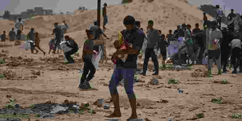 Palestinians run with aid collected from a distribution point in southern Gaza. 