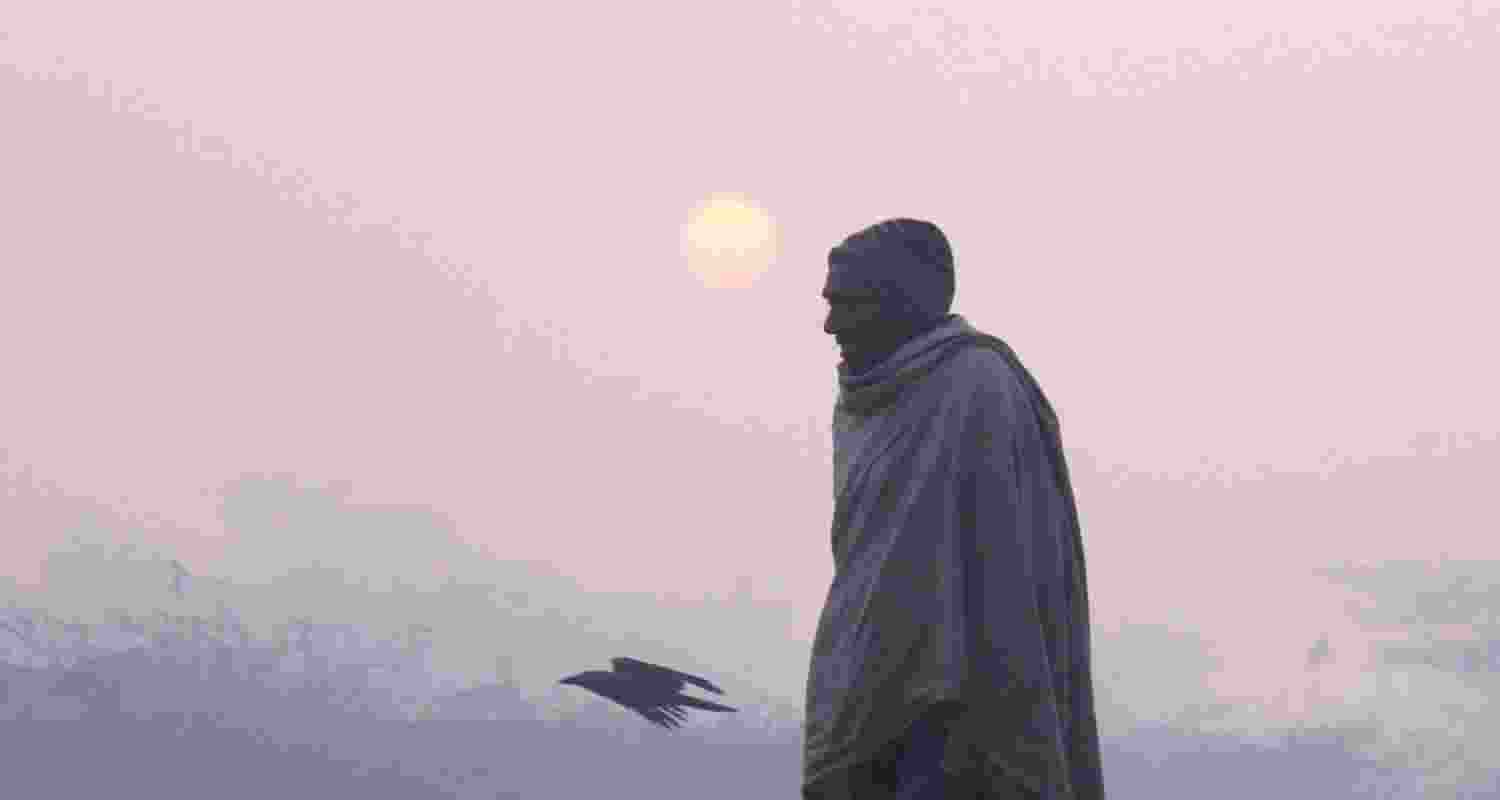 A man walks during a foggy and cold winter morning, in Gurugram. 