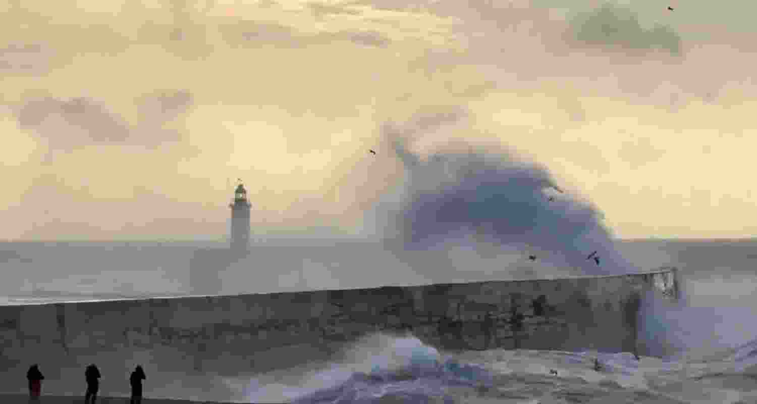 Waves crashing against a pier on Cornwall, United Kingdom as storm Herminia reaches the country.