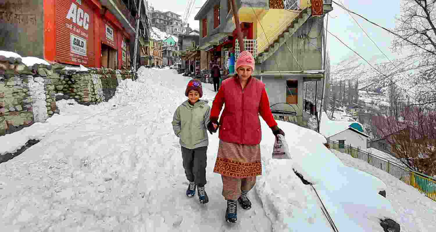 A woman with her child after a heavy snowfall, in Lahaul & Spiti district, Himachal Pradesh. 