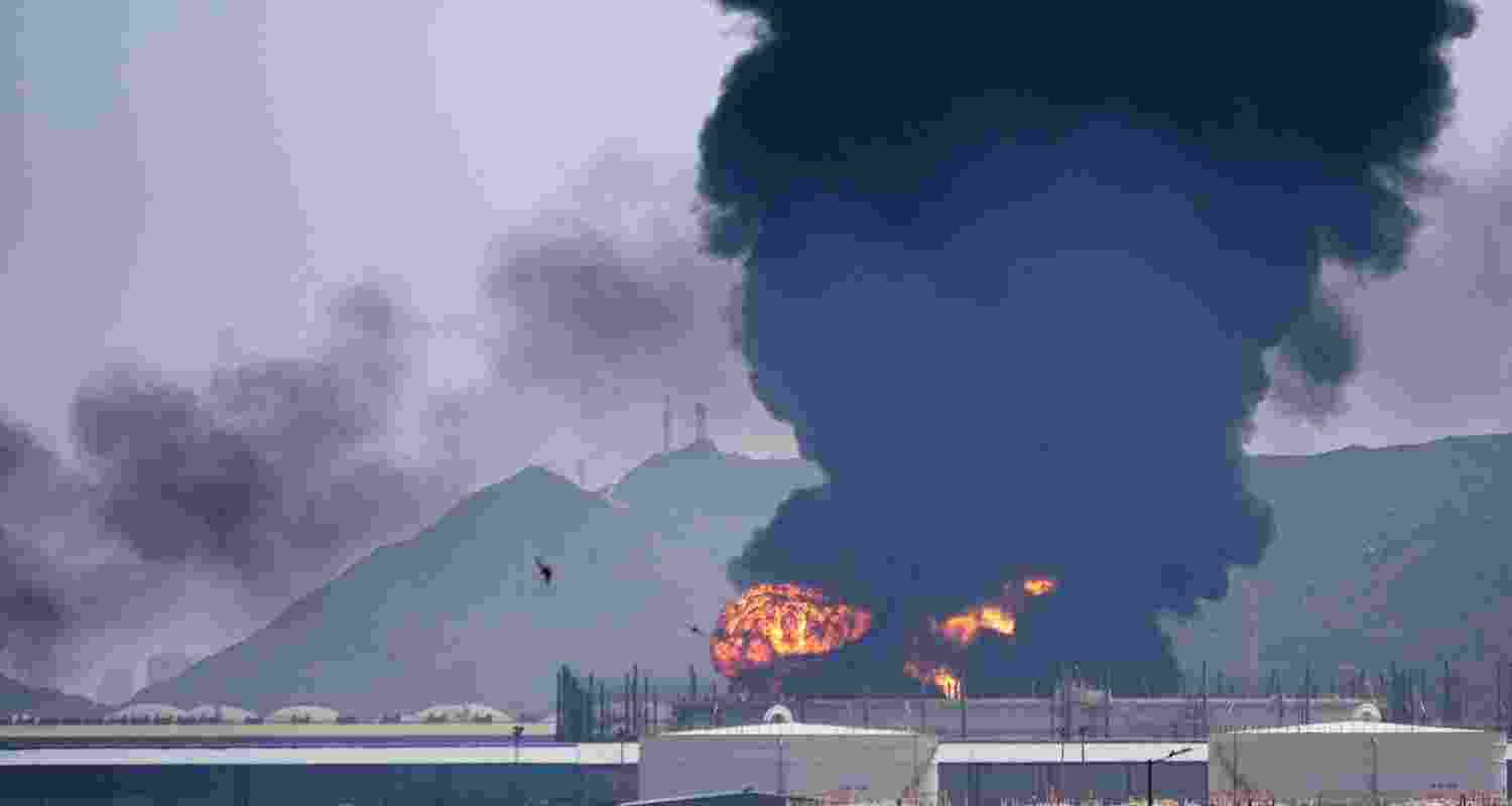 A fire and plume of smoke rise after, according to authorities. debris from an intercepted Iranian drone struck an oil facility in Fujairah, United Arab Emirates, Saturday, March 14, 2026.