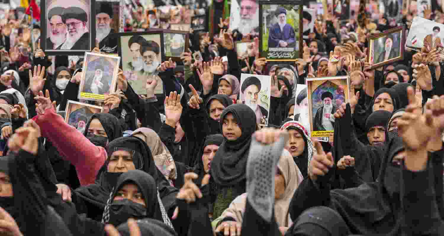 People hold portraits of Iran's late Supreme Leader Ayatollah Ali Khamenei during a protest against his killing, while defying curfew-like restrictions imposed by authorities on third consecutive day as precautionary measures amid the ongoing Israel-Iran conflict, at Magam, in Budgam district, Jammu and Kashmir, Wednesday. 