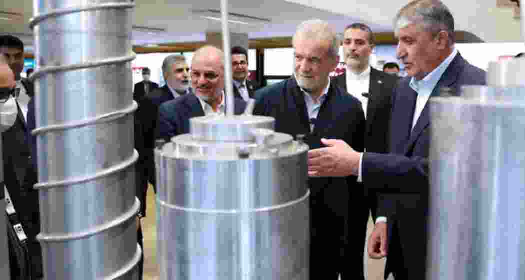 A handout picture provided by the Iranian presidency shows President Masoud Pezeshkian (2nd R) and the Atomic Energy Organisation of Iran (AEOI) chief Mohammad Eslami (R) during the "National Day of Nuclear Technology", in Tehran, on April 9, 2025 (Image: Iranian Presidency)
