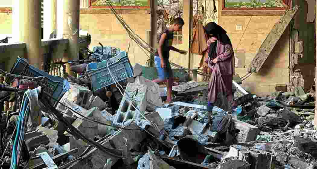 Palestinians inspect the ruins of a school struck by Israeli air raids in Gaza's Sheikh Ridwan, where at least nine people were killed amid rising civilian casualties.

