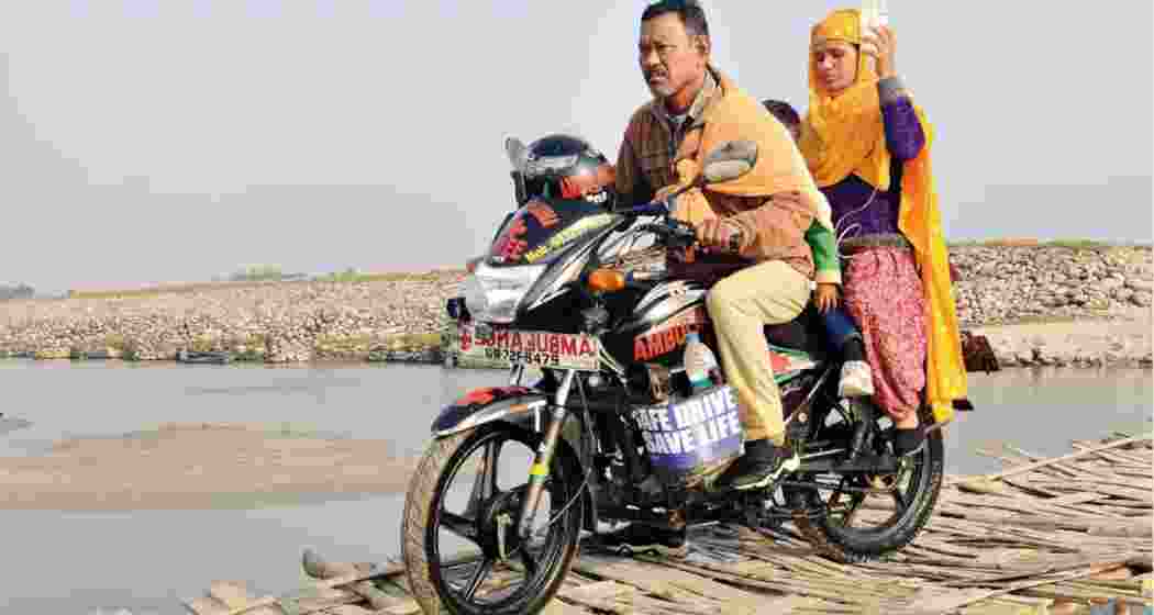 Karimul Haque transports a woman and her children to a nearby hospital, carefully riding across a fragile, makeshift bridge stitched together with bamboo in a remote area in West Bengal's Dooars region. (Photo: Special arrangment)