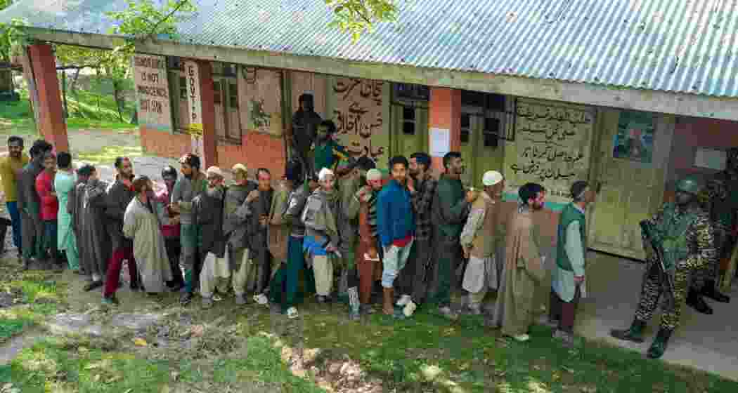 People wait in a queue to cast their votes at a polling booth during the sixth phase of Lok Sabha elections, at Noorbabad area in Kulgam district of South Kashmir on Saturday, May 25, 2024.