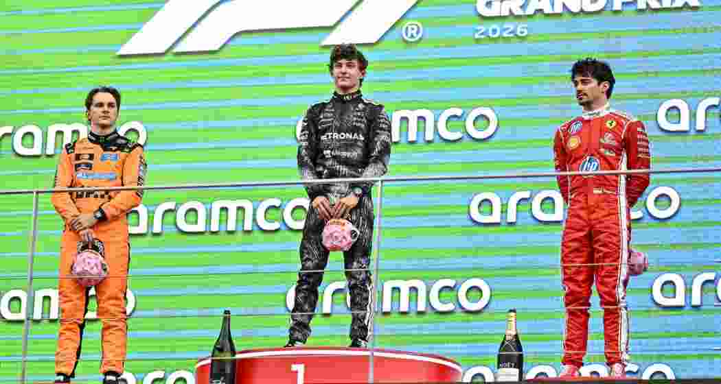 Race winner Kimi Antonelli (C) pose for photogrpahs with Oscar Piastri (L) and Charles Leclerc (R) on the podium.