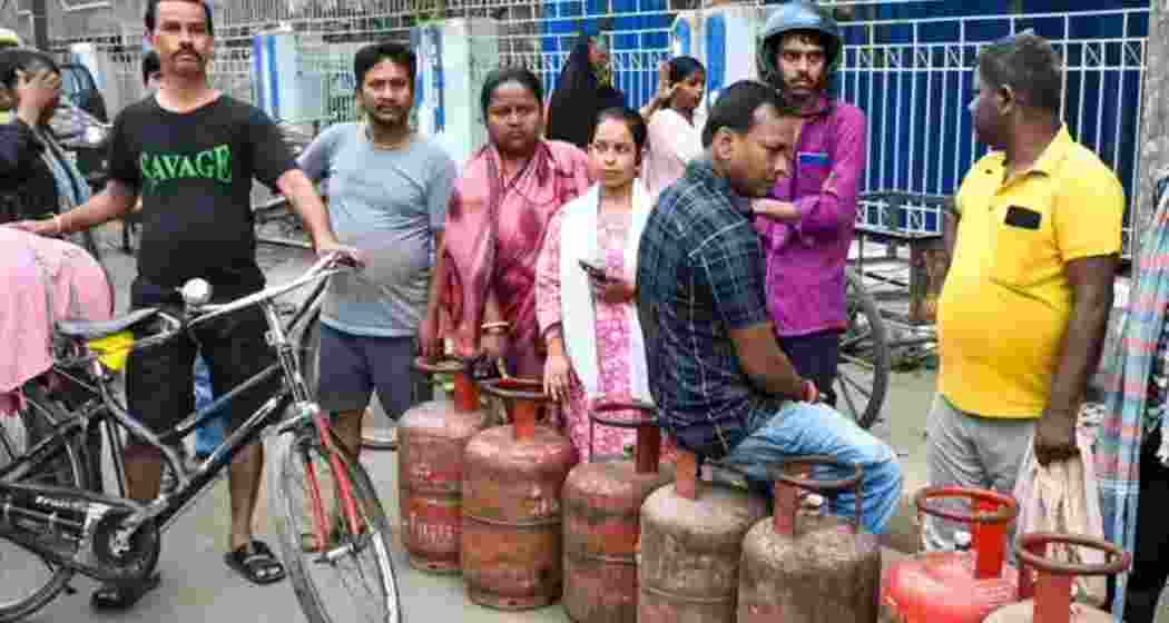 People queue up to book LPG cylinders at a gas agency.