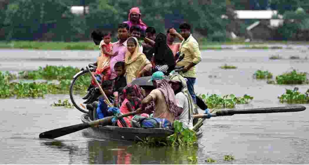 Residents of Katahguri village along the Brahmaputra, east of Guwahati, relocate to safer areas amid severe flooding in Assam.
