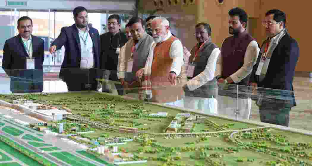 Prime Minister Narendra Modi reviews a model of the new terminal building at Guwahati airport in the presence of Union and state ministers, including Assam Chief Minister Himanta Biswa Sarma.