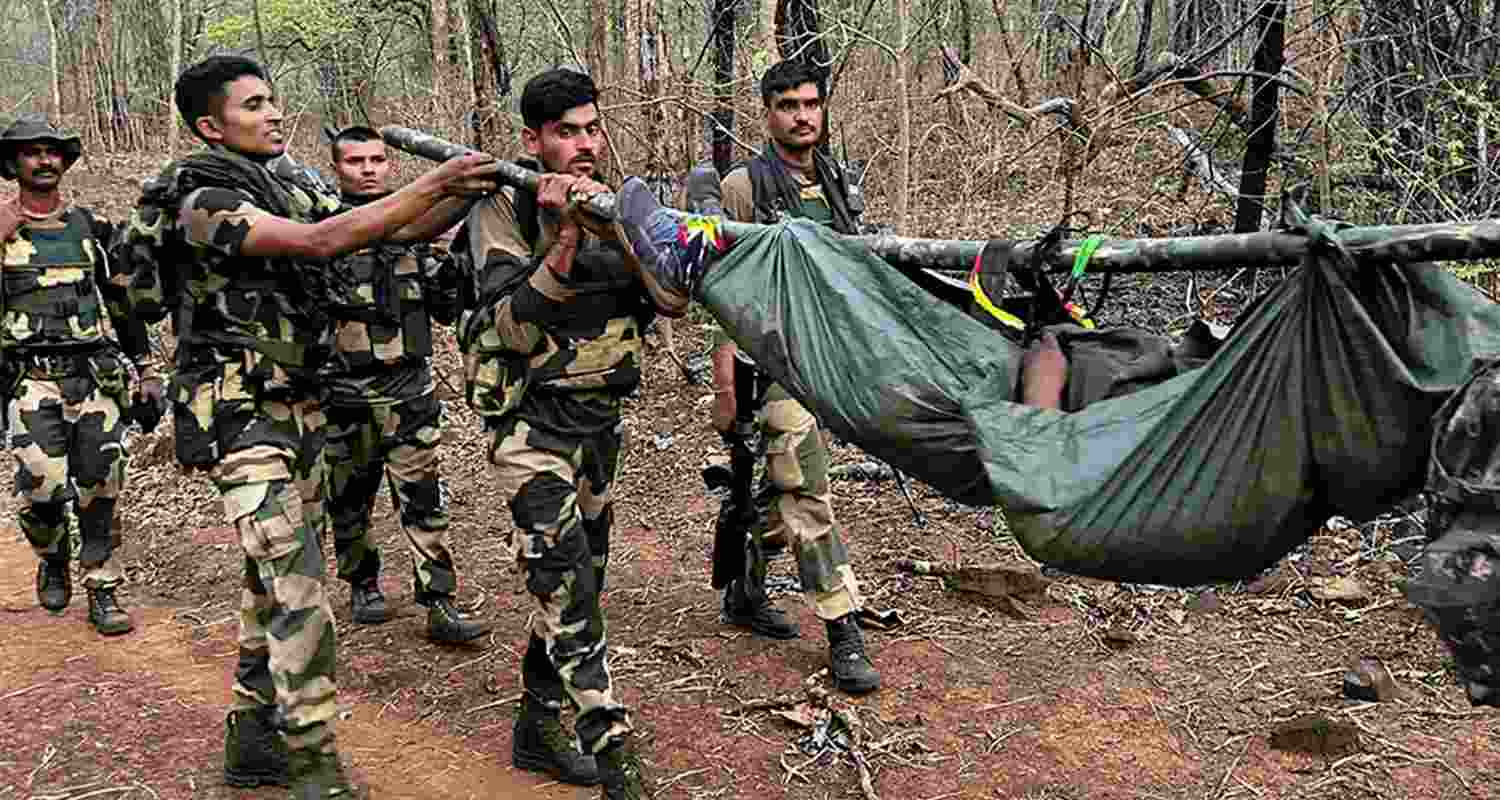 Security personnel carrying dead bodies of slain Naxalites. Security personnel carrying dead bodies of slain Naxalites.