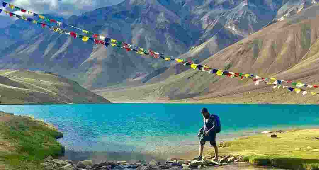 Trekker making his way across the scenic Chandertal Lake in Himachal