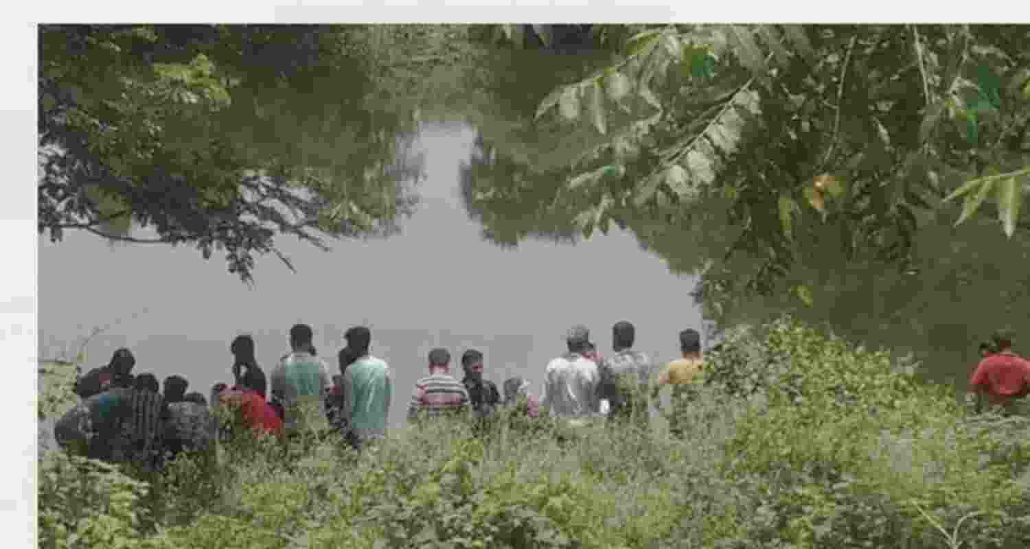 Locals gathered around the pond where the recovery was made. Image via special arrangement.