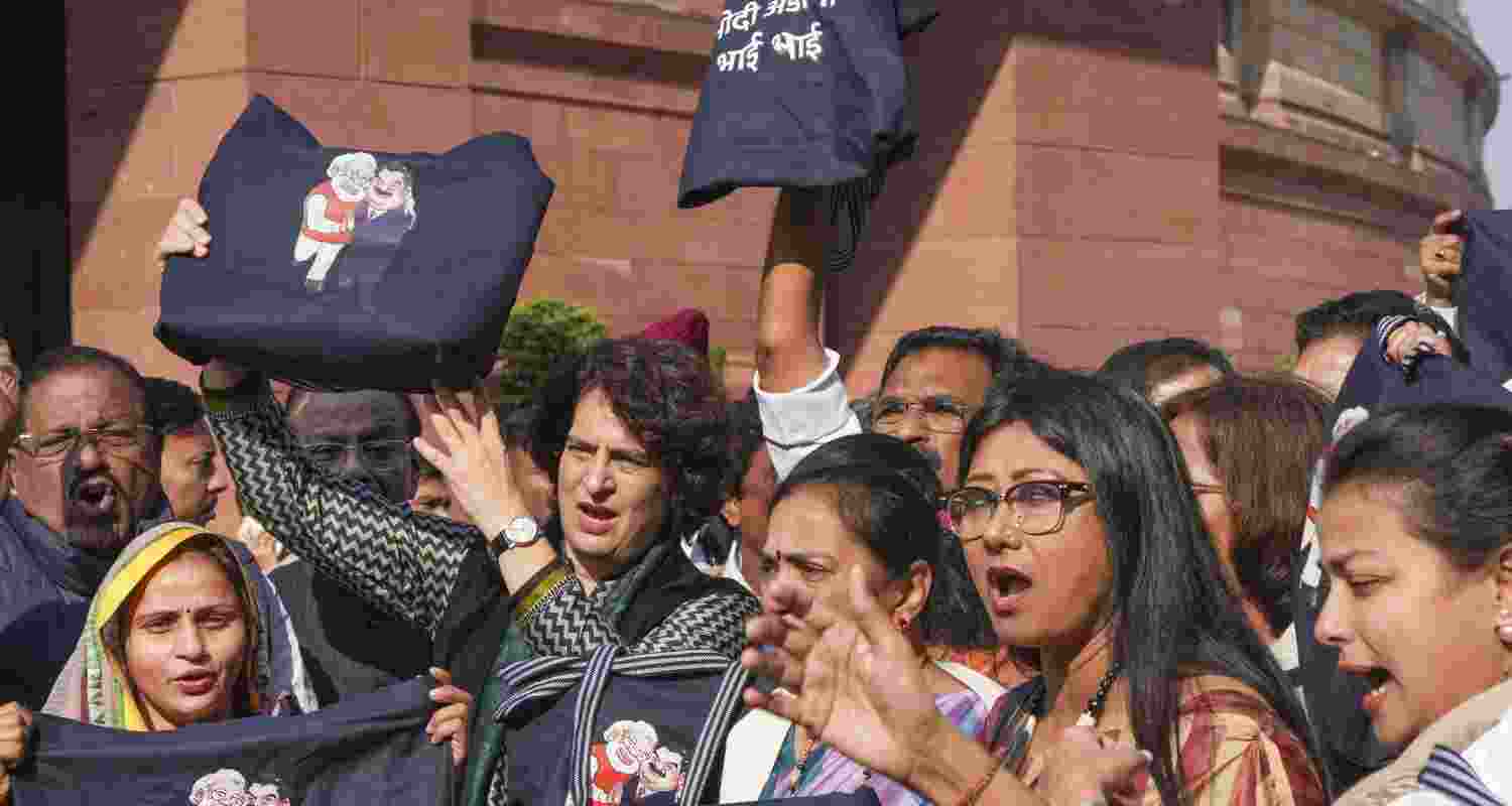 Congress MP Priyanka Gandhi Vadra and other INDIA bloc MPs stage a protest over indictment of industrialist Gautam Adani by a US court in a bribery case, during the Winter session of Parliament, in New Delhi, Tuesday.