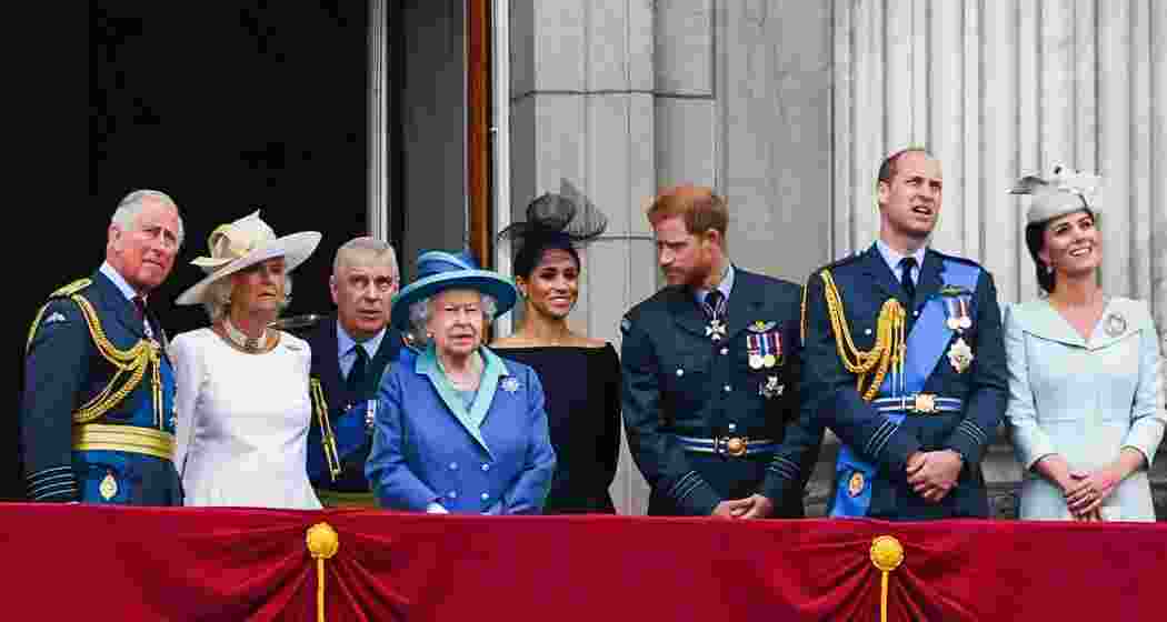 Prince Charles, Camilla, Duchess of Cornwall, Prince Andrew, Queen Elizabeth II, Meghan, Duchess of Sussex, Prince Harry, Prince William, and Catherine, Duchess of Cambridge, stand on the Buckingham Palace balcony to watch a flypast marking the centenary of the Royal Air Force on 10 July 2018 in London, England.