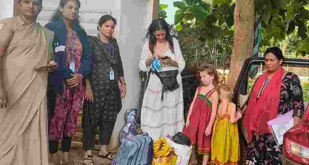 Nina Kutina (in white dress), waiting at a detention center  in Karnataka along with her children, on Monday. The Russian national and her two daughters had been found living in a cave in the region. (Image: Office of the Superintendent of Police, Uttara Kannada District, Karnataka)
