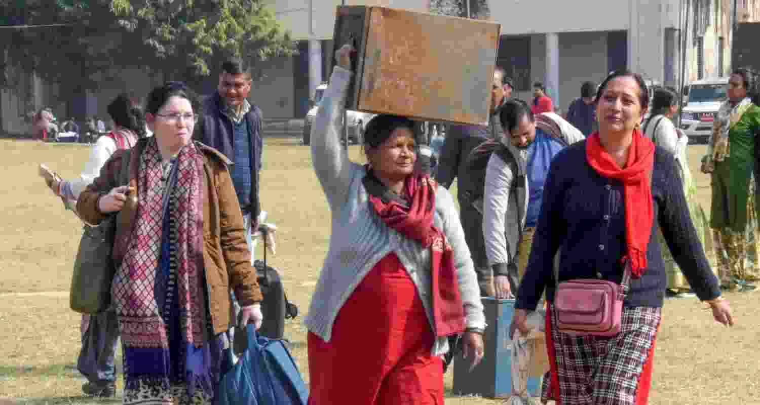 Polling officials with election material leave for their respective polling booths on the eve of the urban local body polls, in Haridwar, Uttarakhand, Wednesday. 