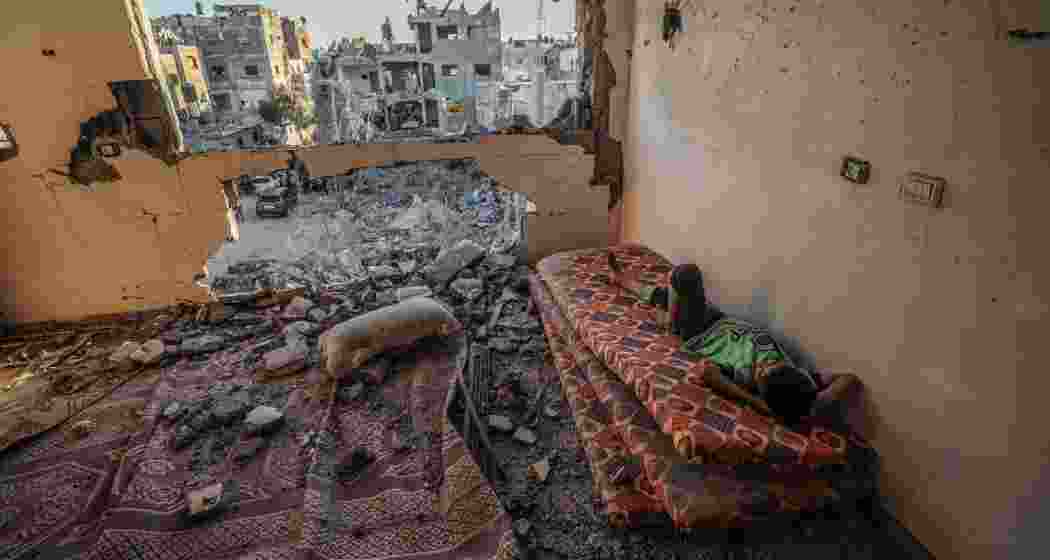 A boy looking through the damaged walls of his house in Gaza. (Image: UNDP)