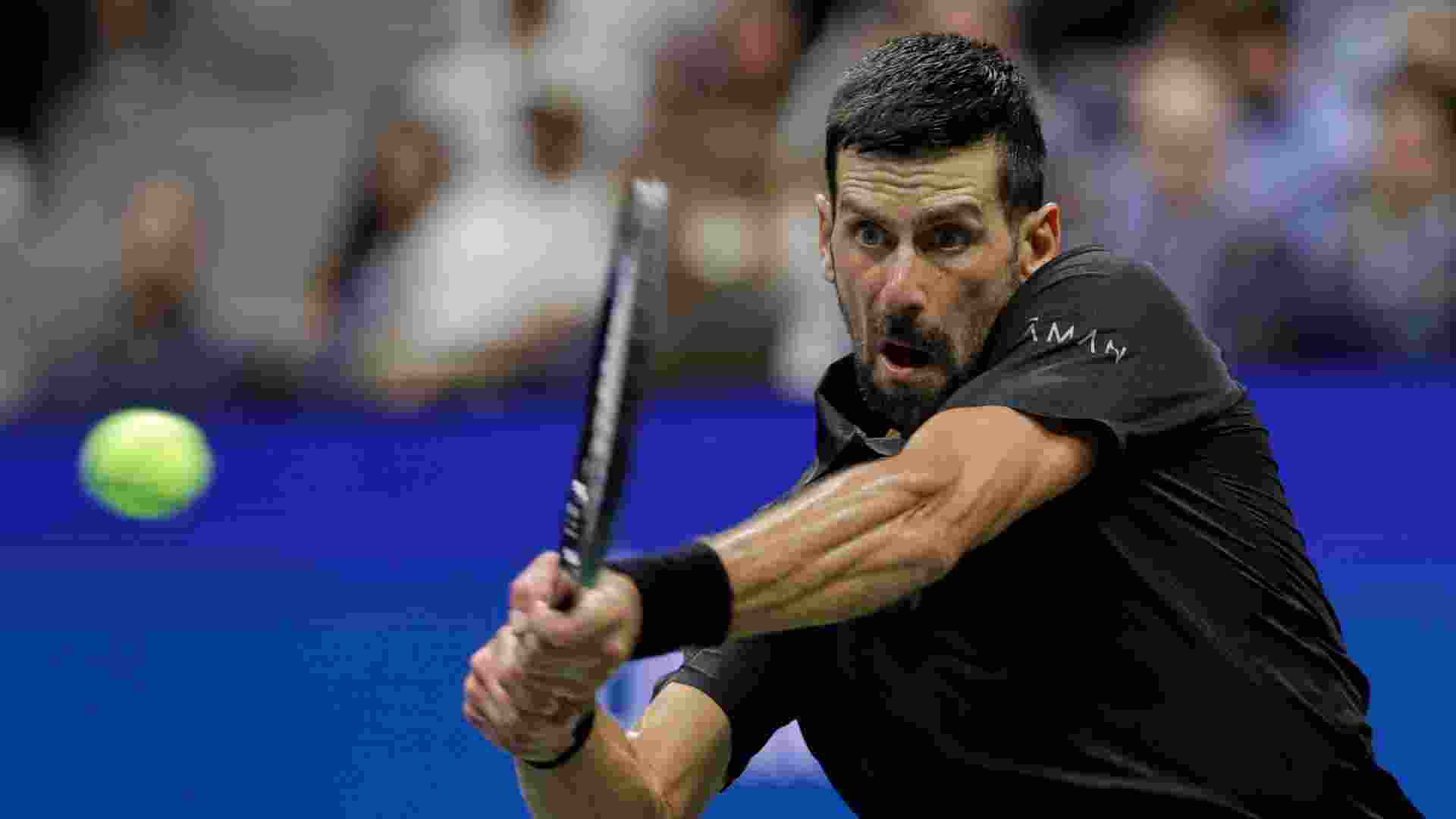 Novak Djokovic of Serbia returns a shot against Taylor Fritz of the United States during the quarterfinal round of the US Open.