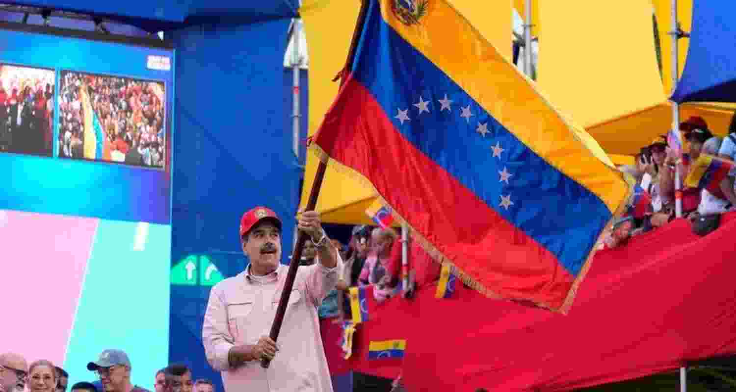 President Nicolas Maduro waves a Venezuelan flag during a swearing-in event for government-organized community committees at the presidential palace in Caracas, Venezuela, Monday.