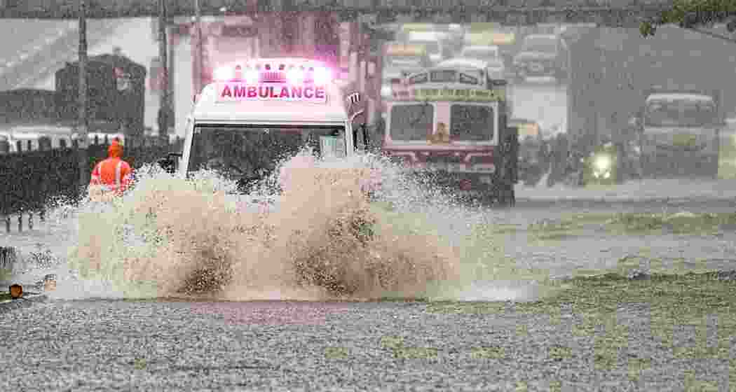 An ambulance wades through a waterlogged road following rainfall, in Mumbai.