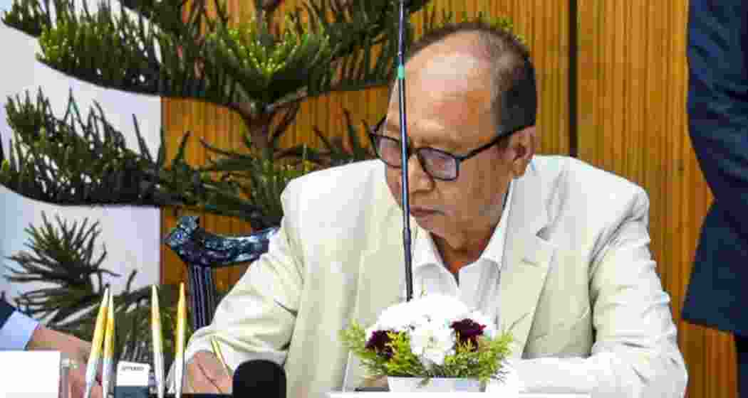  BJP legislator Yumnam Khemchand Singh signs during his swearing-in as new Manipur Chief Minister, in Imphal, Manipur on Wednesday.