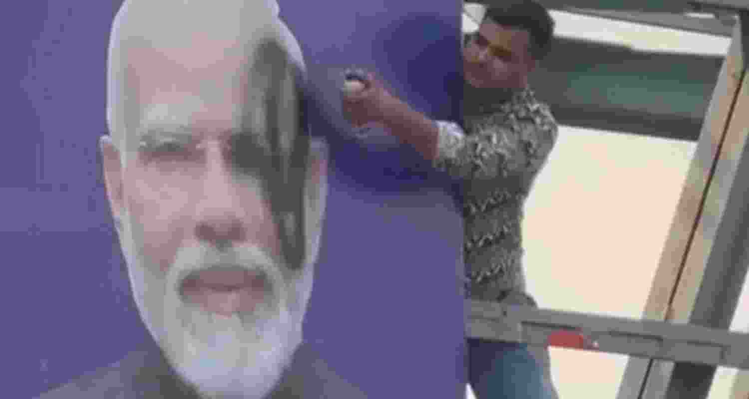 A youth spray-paints the face of Prime Minister Narendra Modi black on a poster in Panipat. A youth spray-paints the face of Prime Minister Narendra Modi black on a poster in Panipat.