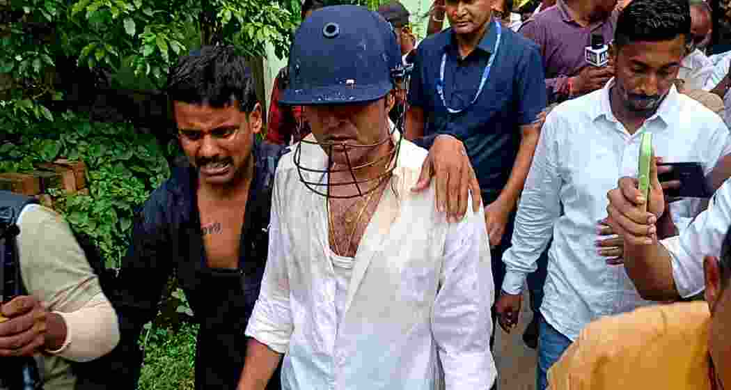 TMC national general secretary and MP Abhishek Banerjee, wearing a protective helmet, is escorted by security personnel and party workers after coming under attack from protesters during a visit to families of alleged post-poll violence victims in Sonarpur, South 24 Parganas, on Saturday. TMC national general secretary and MP Abhishek Banerjee, wearing a protective helmet, is escorted by security personnel and party workers after coming under attack from protesters during a visit to families of alleged post-poll violence victims in Sonarpur, South 24 Parganas, on Saturday.