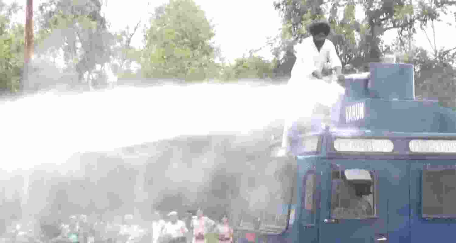 Akali Dal Waris Punjab De worker climbs over a water cannon vehicle during a protest Akali Dal Waris Punjab De worker climbs over a water cannon vehicle during a protest
