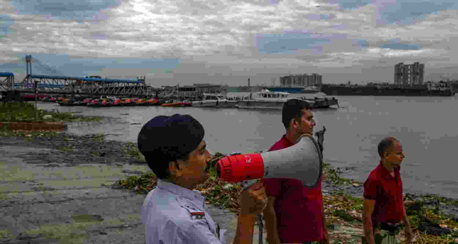 Officials of the River Traffic Police and Disaster Management Group (DMG) make announcements on the banks of the Hooghly river ahead of ahead of Cyclone 'Dana' landfall, in Kolkata, Wednesday. Officials of the River Traffic Police and Disaster Management Group (DMG) make announcements on the banks of the Hooghly river ahead of ahead of Cyclone 'Dana' landfall, in Kolkata, Wednesday.