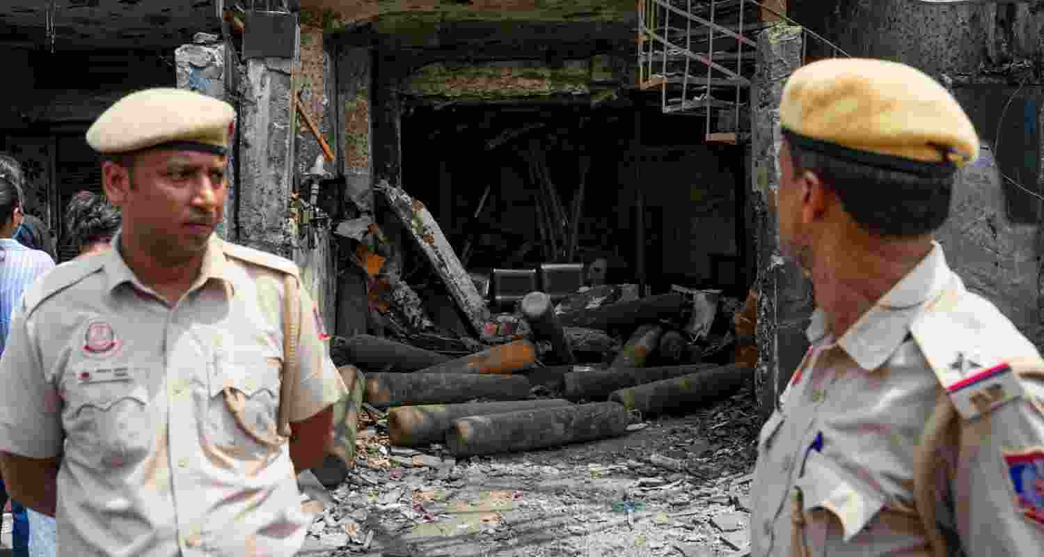 Cops stand at the site of the Delhi hospital fire. Cops stand at the site of the Delhi hospital fire.