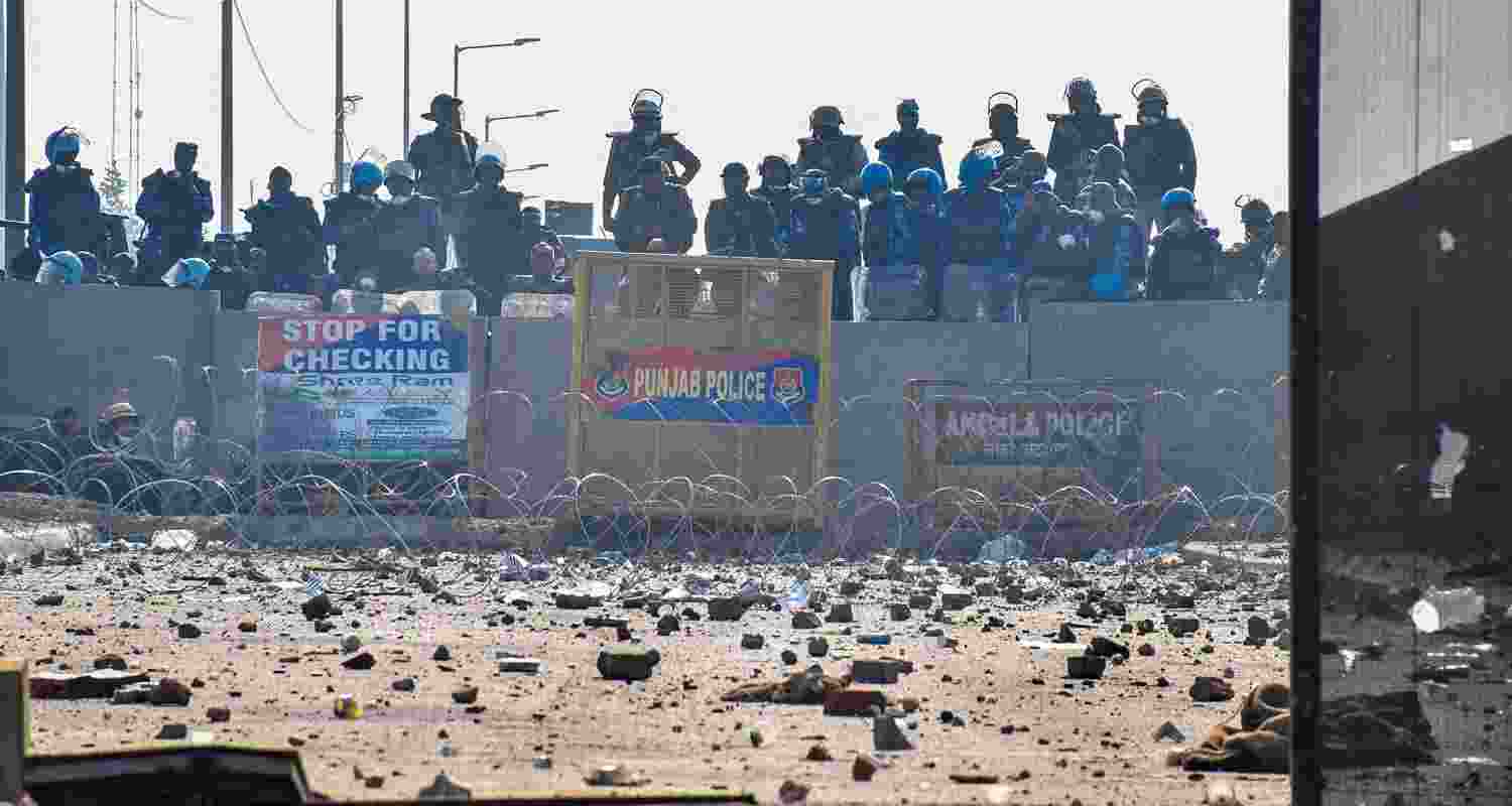 Security personnel stand guard as brick bats and stones lie on the roads at the Punjab-Haryana Shambhu border during farmers' 'Delhi Chalo' march, near Patiala district. Security personnel stand guard as brick bats and stones lie on the roads at the Punjab-Haryana Shambhu border during farmers' 'Delhi Chalo' march, near Patiala district.