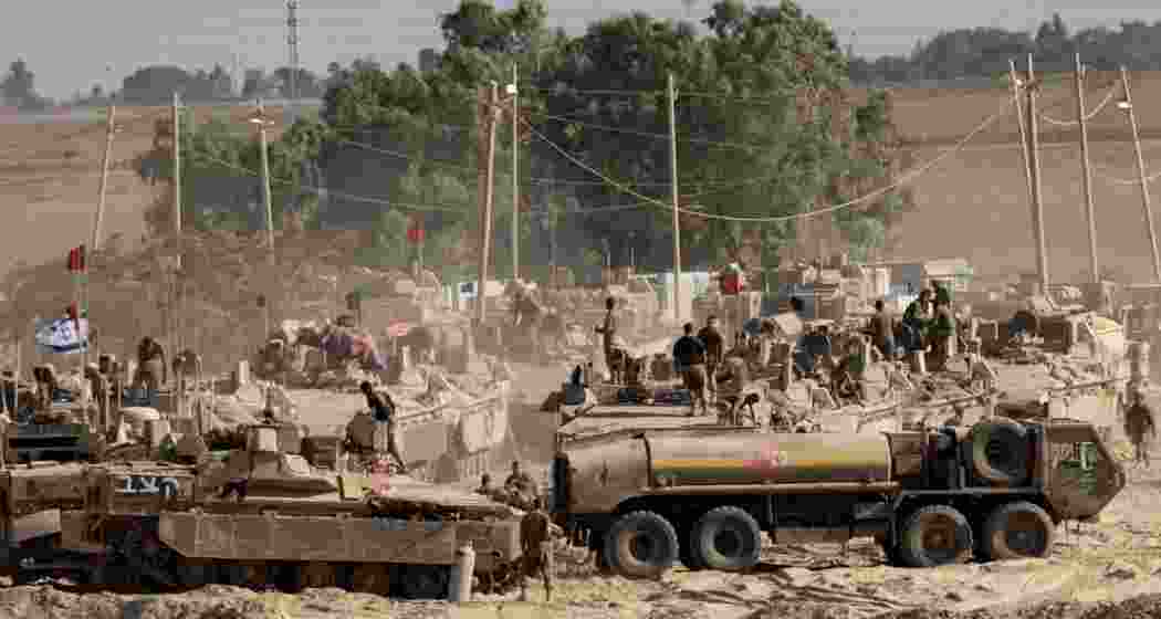 Israeli soldiers organize military equipment while standing on armored personnel carriers near the border with the Gaza Strip. Israeli soldiers organize military equipment while standing on armored personnel carriers near the border with the Gaza Strip.